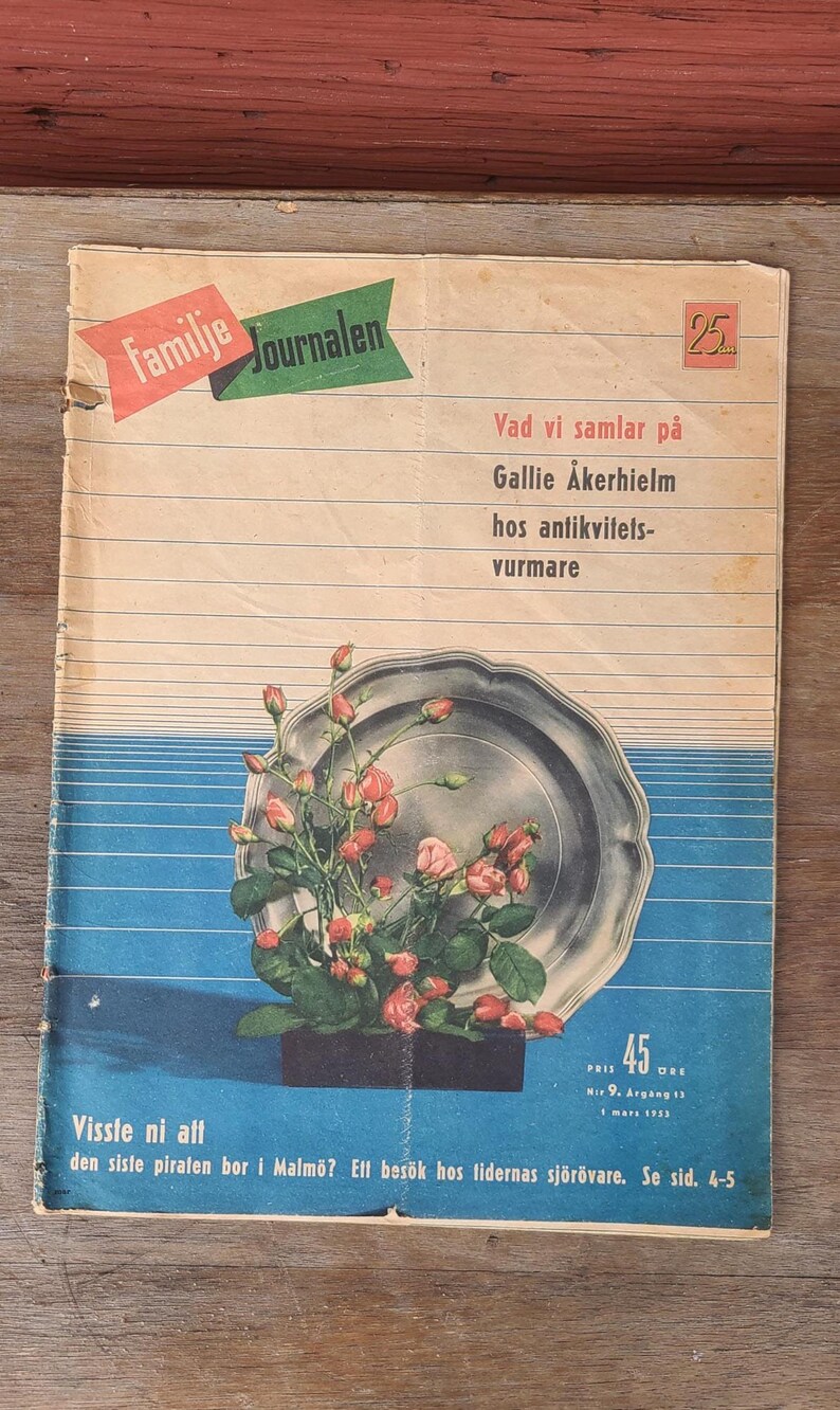 Puede incluir: Una revista vintage titulada Familie Journalen con una ilustraci&oacute;n central de una bandeja de plata llena de capullos de rosa rosados. La portada incluye texto en sueco, un fondo de rayas azules horizontales y un precio de 45 &ouml;re de marzo de 1953.