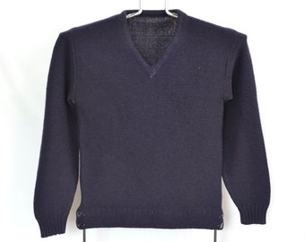 Könnte beinhalten: Ein dunkelblauer V-Ausschnitt-Pullover mit langen Ärmeln und Knopfdetails an den Manschetten.
