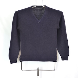 May include: A dark blue v-neck sweater with long sleeves and button details on the cuffs.