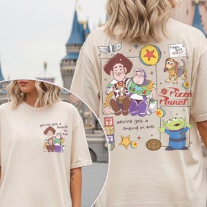 Puede incluir: Camiseta beige con un gr&aacute;fico colorido de los personajes de Toy Story, incluyendo a Woody, Buzz Lightyear y los peque&ntilde;os hombres verdes. Tambi&eacute;n se muestra el texto "You've got a friend in me". La camiseta tiene mangas cortas.