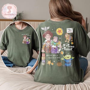 Puede incluir: Camiseta verde oliva con un gr&aacute;fico de Woody, Buzz Lightyear y otros personajes de la pel&iacute;cula Toy Story. La parte trasera de la camiseta tiene un gr&aacute;fico m&aacute;s grande con el texto "Pizza Planet" y "You've got a friend in me."