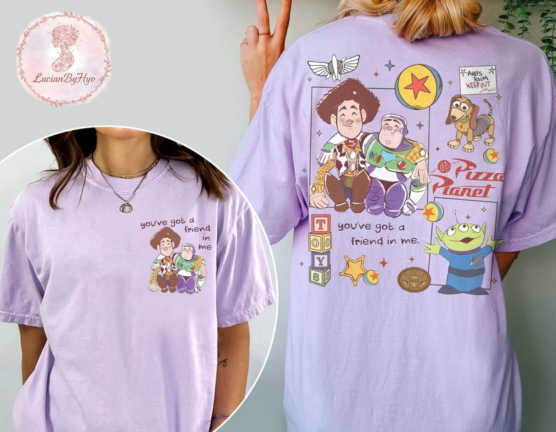 Puede incluir: Camiseta lila con un dise&ntilde;o de Toy Story. La parte delantera muestra a Woody y Buzz Lightyear con el texto "you've got a friend in me". La parte trasera presenta m&aacute;s personajes y el logo de Pizza Planet.