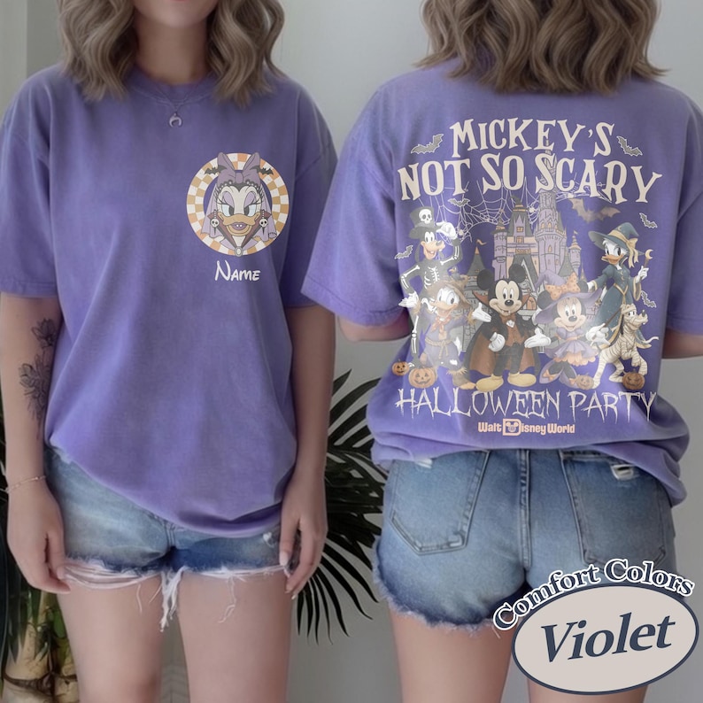 May include: Violet Comfort Colors t-shirt featuring a Daisy Duck graphic with the word "Name" and a Halloween-themed design. The back of the shirt has a "Mickey's Not So Scary Halloween Party" design with Disney characters.