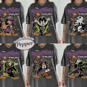 May include: Dark gray t-shirts with Halloween-themed graphics. Each shirt features a different character from a popular animated movie, with the words "Nightmare on Main Street" in purple. The shirts are from Comfort Colors.