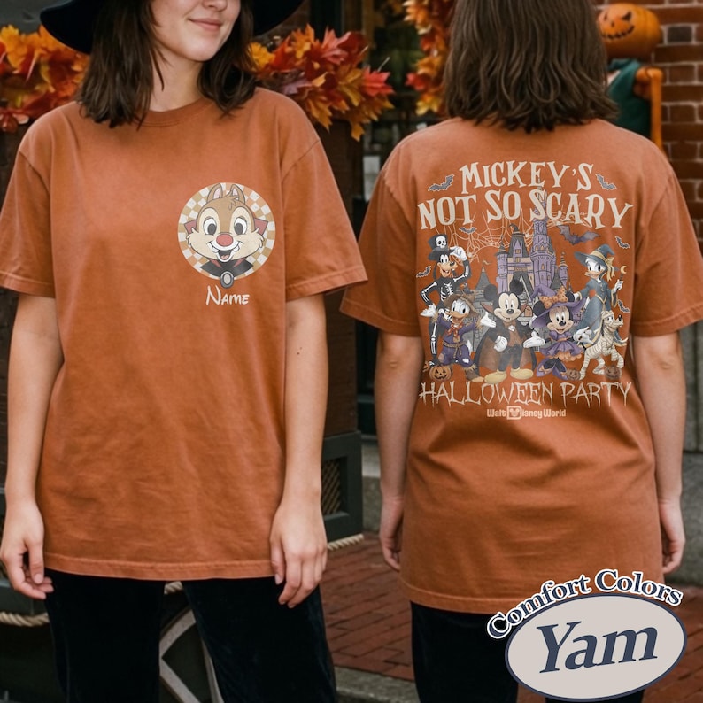 May include: A burnt orange t-shirt featuring a cartoon character on the front and a Halloween-themed graphic on the back. The front of the shirt has a circular design with a cartoon character and the word "Name". The back of the shirt has the text "Mickey's Not So Scary Halloween Party".