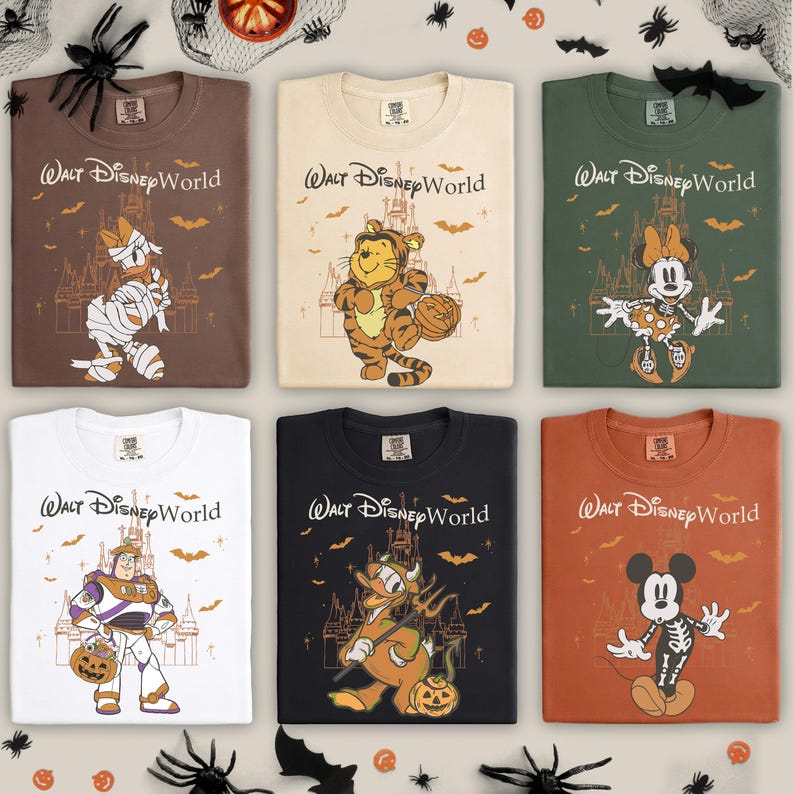 以下が含まれることがあります： ディズニーキャラクターが描かれた、ハロウィーンをテーマにしたTシャツ6枚。各シャツには「ウォルト・ディズニー・ワールド」と、ミイラ、トラ、スケルトンなど、ハロウィーンのコスチュームを着たキャラクターが描かれています。シャツの色は、茶色、白、オレンジなど様々です。