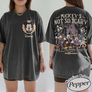 May include: Dark grey t-shirt featuring Mickey Mouse in a Halloween-themed design. The front displays Mickey with the word "Daddy" below. The back showcases various Disney characters in costume with the text "Mickey's Not So Scary Halloween Party".