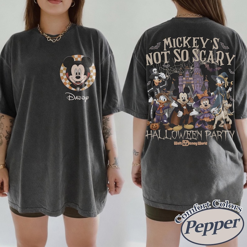 May include: Dark grey t-shirt featuring Mickey Mouse in a Halloween-themed design. The front displays Mickey with the word "Daddy" below. The back showcases various Disney characters in costume with the text "Mickey's Not So Scary Halloween Party".