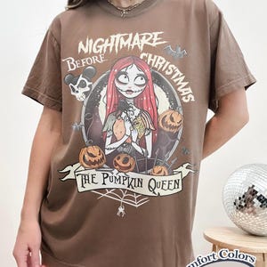 Puede incluir: Camiseta marr&oacute;n con un dise&ntilde;o gr&aacute;fico de "Pesadilla antes de Navidad". El dise&ntilde;o incluye a Sally, calabazas y el texto "The Pumpkin Queen". La camiseta est&aacute; etiquetada como "Comfort Colors Espresso".
