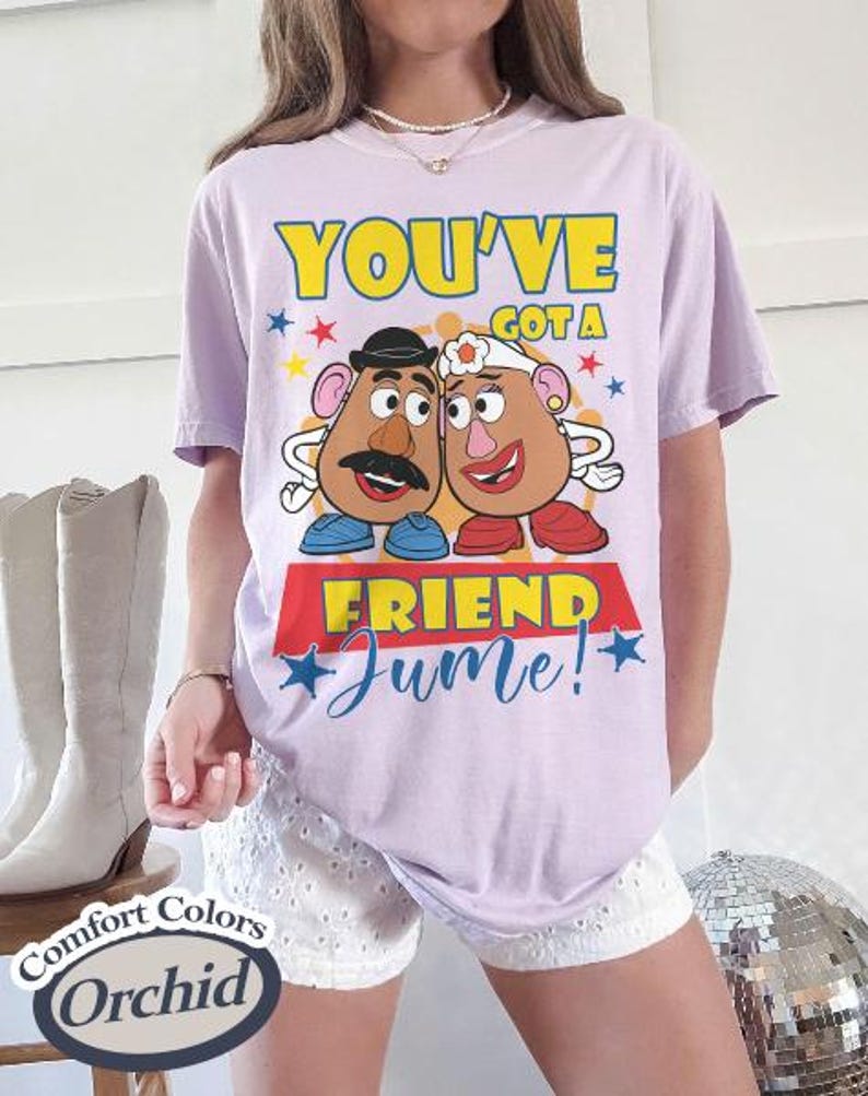 Op de afbeelding: Een lichtpaars T-shirt met de tekst "YOU'VE GOT A FRIEND Jume!" en een afbeelding van twee aardappelvormige personages. Het shirt is van het merk Comfort Colors in de kleur Orchid.