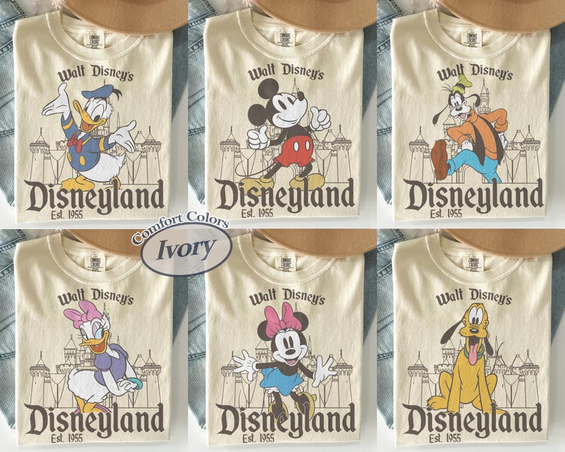 Puede incluir: Camisetas color marfil con varios personajes de Disney: Pato Donald, Mickey Mouse, Goofy, Daisy Duck, Minnie Mouse y Pluto. Cada camiseta muestra "Walt Disney's Disneyland Est. 1955" en un estilo vintage.