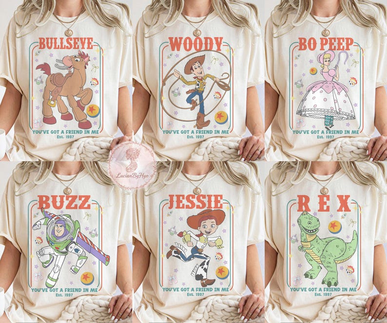 May include: Cream-colored t-shirts featuring cartoon characters from the movie Toy Story. Each shirt displays a different character: Bullseye, Woody, Bo Peep, Buzz, Jessie, and Rex, with the text "You've Got a Friend in Me" and "Est. 1997".