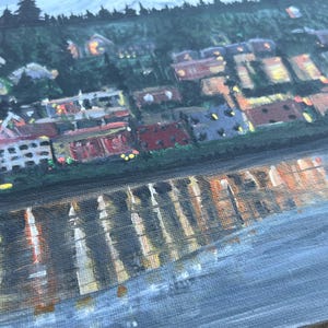 May include: A painting of a city skyline at night with a reflection of the city lights in the water below. The buildings are painted in shades of brown, red, and yellow, and the water is a dark blue.