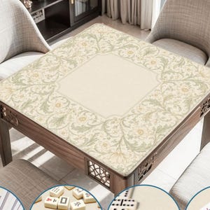 May include: A square mahjong table featuring a light beige fabric cover with a detailed sage green and cream floral vine pattern. The table has a wooden frame with decorative lattice cutouts on the sides and is surrounded by four upholstered chairs.