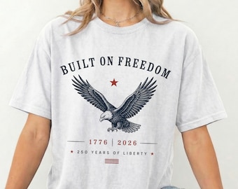 自由の上に築かれたシャツ、イーグル愛国Tシャツ、アメリカ建国250周年記念シャツ、ヴィンテージUSAイーグルシャツ、1776-2026リバティTシャツ