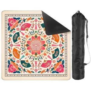 Pode incluir: Um tapete de ioga creme com um design floral e de leque colorido e uma bolsa de transporte preta. O tapete apresenta detalhes em rosa, laranja e verde-azulado, com um padr&atilde;o circular central e uma borda de pequenas estrelas.