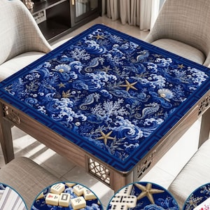 Puede incluir: Un tapete cuadrado para mesa de mahjong con fondo azul profundo y un patr&oacute;n repetitivo de olas blancas, estrellas de mar doradas, caballitos de mar, corales y conchas. La tela presenta un borde geom&eacute;trico de color azul oscuro.
