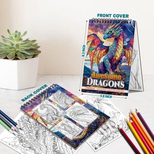Może przedstawiać: Spiralna książka do kolorowania zatytułowana "Awesome Dragons" z kolorową ilustracją smoka na okładce. Książka ma 21 cm wysokości i 14,7 cm szerokości. Na tylnej okładce znajdują się szkice smok&oacute;w. Rozrzucone kredki.