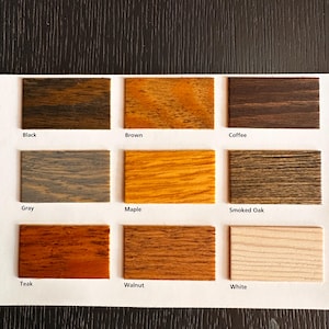 May include: A color swatch chart featuring nine wood stain samples. The samples include Black, Brown, Coffee, Gray, Maple, Smoked Oak, Teak, Walnut, and White. Each sample is labeled with its respective color name.