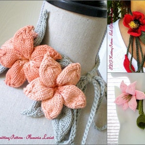 Pode incluir: Três colares de lariat de flores de tricô. O primeiro é uma flor cor de pêssego com folhas cinzas. O segundo é uma flor vermelha com folhas verdes. O terceiro é uma flor rosa com folhas verdes.