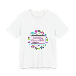 Könnte beinhalten: Weißes T-Shirt mit einem Retro-Grafikdesign. Das Design zeigt einen Ladebildschirm mit dem Text "Loading... Please Wait." umgeben von Herzen, Sternen und Disketten. Das T-Shirt ist aus einem weichen Material gefertigt.