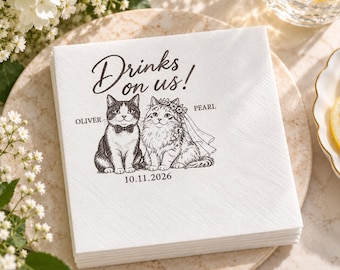 Può includere: Un tovagliolo di carta quadrato bianco con un'illustrazione a inchiostro nero di due gatti. Un gatto indossa un papillon ed è chiamato Oliver, l'altro indossa una corona di fiori e un velo ed è chiamato Pearl. Il testo recita Drinks on us! e 10.11.2026.