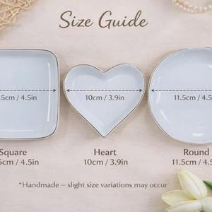 Puede incluir: Un conjunto de tres platos blancos de cer&aacute;mica en formas cuadrada, coraz&oacute;n y redonda con bordes plateados. Los platos cuadrado y redondo miden 11,5 cm, mientras que el plato en forma de coraz&oacute;n mide 10 cm. Texto: Size Guide, Square, Heart, Round, Handmade.