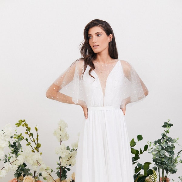 The perfect dress for your fairytale wedding. Whimsical wedding dress with delicate cape design handmade from dreamy pearl embroidered tulle