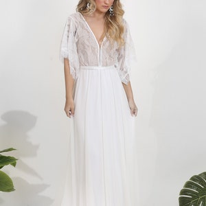 May include: A white lace and chiffon maxi dress with a V-neckline and 3/4 sleeves. The dress has a fitted bodice and a flowing skirt.