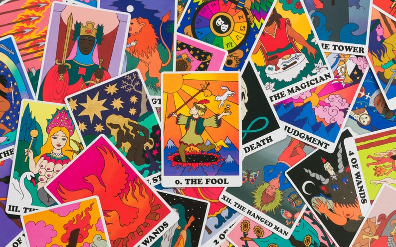 Tossed cards from the Rainbow Heart Tarot with The Fool card displayed prominently in the middle- cards feature a retro groovy psychedelic illustration style