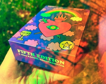 May include: A box of tarot cards with a colorful illustration of a heart with an eye, a rainbow, and clouds. The box is labeled "FIFTH EDITION © 2023 RACHEL ROSENKOETTER".
