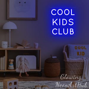 May include: A neon sign in blue, displaying the text "COOL KIDS CLUB" in white. The sign is in a child's room, with a wooden shelf, toys, and a woven basket. The room has a neutral colour scheme.