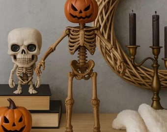 Może przedstawiać: Wystawa o tematyce Halloween z figurą szkieletu z dyniową głową. Mniejsza figura czaszki i wyrzeźbiona dynia są również obecne. Ozdobny wieniec i świecznik z czarnymi świecami dopełniają scenę.