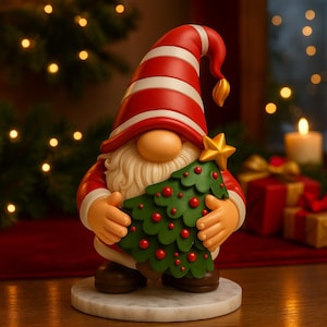以下が含まれることがあります： 赤と白のストライプの帽子と長い白いひげを持つクリスマスのノームの置物。ノームは赤いオーナメントと金の星が付いた緑のクリスマスツリーを持っています。置物は大理石の台座にあります。