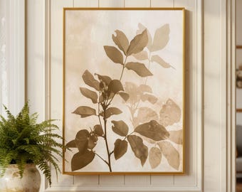 May include: A rectangular wall art print featuring a botanical illustration of a leafy branch in shades of brown and beige. The artwork is encased in a thin gold frame, displaying a layered, semi-transparent effect of foliage against a light background.