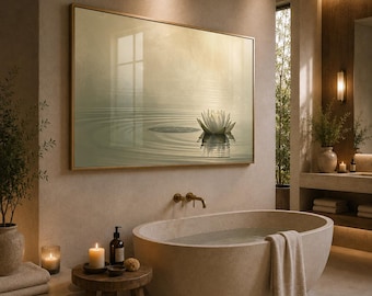 May include: A rectangular wall art piece featuring a white lotus flower floating on calm, rippled water in soft beige and green tones, framed in a thin gold border, displayed above a stone oval bathtub in a neutral-toned bathroom setting.