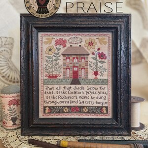 Könnte beinhalten: Ein gerahmtes Kreuzstich-Muster mit dem Titel Creator's Praise, das ein Haus, Blumen, Vögel und den Text zeigt: From all that dwells below the skies, let the Creator's praise arise, let the Redeemer's name be sung through every land by every tongue.
