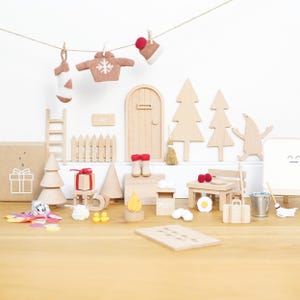 May include: A wooden miniature elf kit featuring a door, fence, trees, ladder, furniture, and accessories. Includes a tiny sweater, stocking, hat, post box, campfire, and gift box. The set contains small items like a broom, bucket, and suitcase.