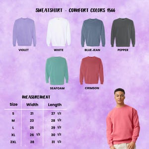 May include: A display of Comfort Colors 1566 sweatshirts in various colors, including violet, white, blue jean, pepper, seafoam, and crimson. The image also includes a size chart with measurements in inches for width and length.