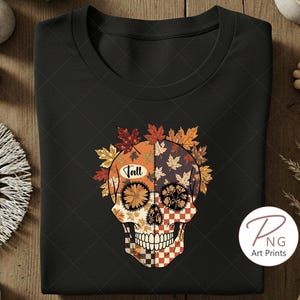 Op de afbeelding: Zwart T-shirt met ronde hals en een kleurrijk suikerschedelontwerp met herfstbladeren. De schedel is versierd met herfstkleuren en het woord "Fall". Een uniek grafisch T-shirt voor het herfstseizoen.