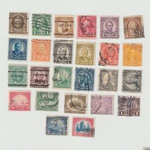 May include: A collection of twenty-eight vintage United States postage stamps arranged in a grid. The stamps feature various portraits, landmarks, and illustrations with denominations ranging from one cent to five dollars, many showing postmark ink.
