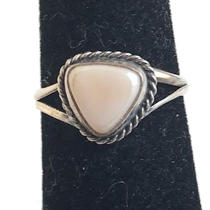 May include: A white ceramic mug with a black handle and the text "But First, Coffee" in a black, bold font. The mug is on a white surface.