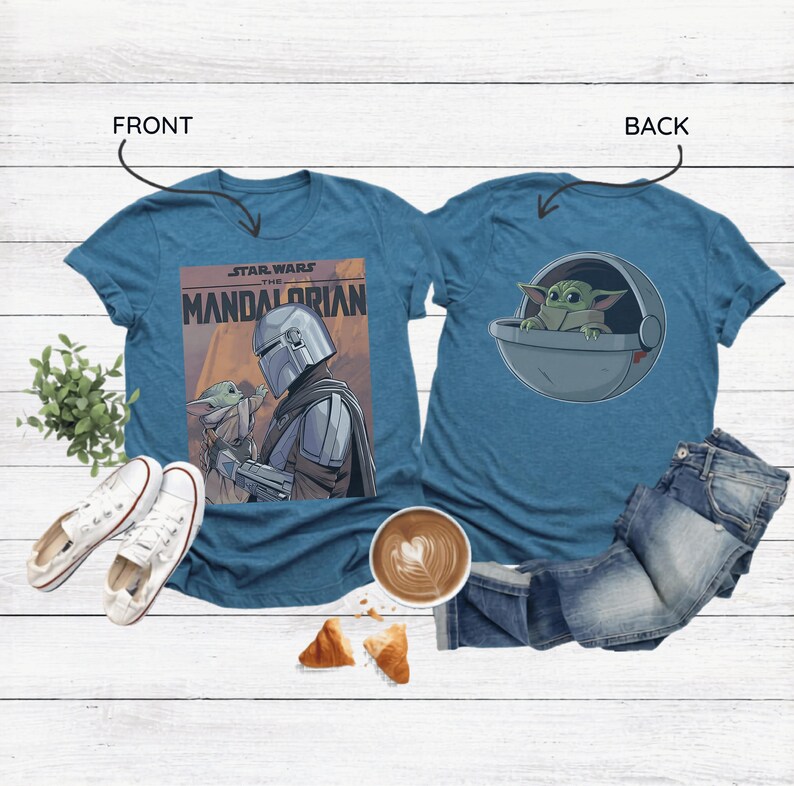 May include: Teal t-shirts featuring Star Wars designs. One shirt displays "The Mandalorian" poster art with the Mandalorian and Grogu. The other shirt shows Grogu in a pod. White sneakers, coffee, and pastries are also in the image.