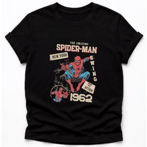 May include: Black t-shirt with a retro Spider-Man design. The graphic includes the words "THE AMAZING SPIDER-MAN" and "NEW YORK". The superhero is shown in action, with the year "1962" featured prominently.