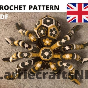 Puede incluir: Una araña grande de ganchillo en tonos negros, amarillos y blancos, con un patrón geométrico detallado. El texto "CROCHET PATTERN PDF" está en la parte superior y "LarriecraftsNL" en la inferior. Una bandera británica está en la esquina superior derecha.