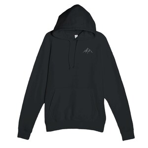 May include: Black hooded sweatshirt with a front pocket and drawstring. A small, embroidered mountain range design is on the upper left chest. The sweatshirt has long sleeves and a hood.
