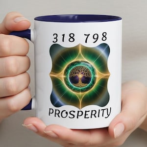 May include: White ceramic mug with a navy blue interior and handle. The mug features a design with the numbers "318 798" above a colorful graphic of a tree inside a circle, with the word "PROSPERITY" below.