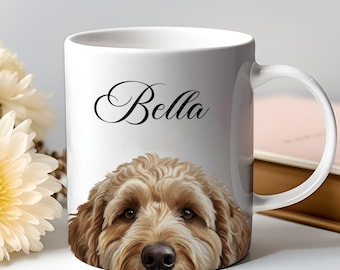 May include: White ceramic mug featuring a close-up of a dog's face with brown fur and dark eyes. The name "Bella" is written in elegant script above the dog. The mug has a white handle and is set against a soft background.