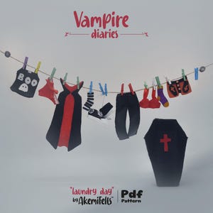 May include: A playful arrangement of felt vampire-themed garments and accessories, such as a cape, trousers, shorts, and a coffin, suspended from a washing line. The words "Vampire diaries" are at the top, and "laundry day" is at the bottom.