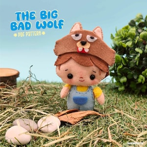 May include: A handmade felt doll wearing a brown wolf hat with a red mouth and white teeth. The doll has brown hair, a yellow shirt, and blue overalls. The text "THE BIG BAD WOLF * PDF PATTERN *" is in the upper left corner. The doll is on a bed of grass.